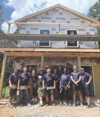 SitusAMC team members in front of a house being built as part of the Habitat For Humanity project
